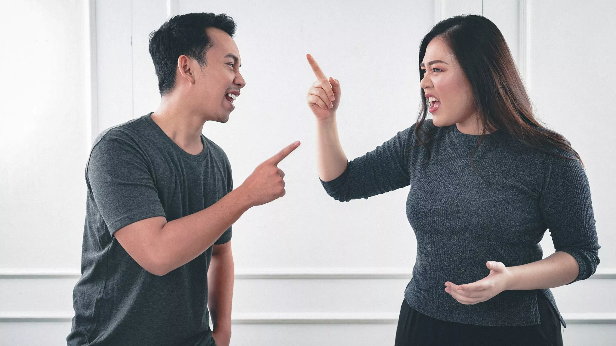 A man and a woman angrily arguing and pointing fingers at each other, representing a family dispute relevant to Nussbaum Family Lawyers in Toronto specializing in family law conflicts.