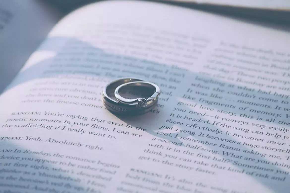 Wedding rings resting on an open book.